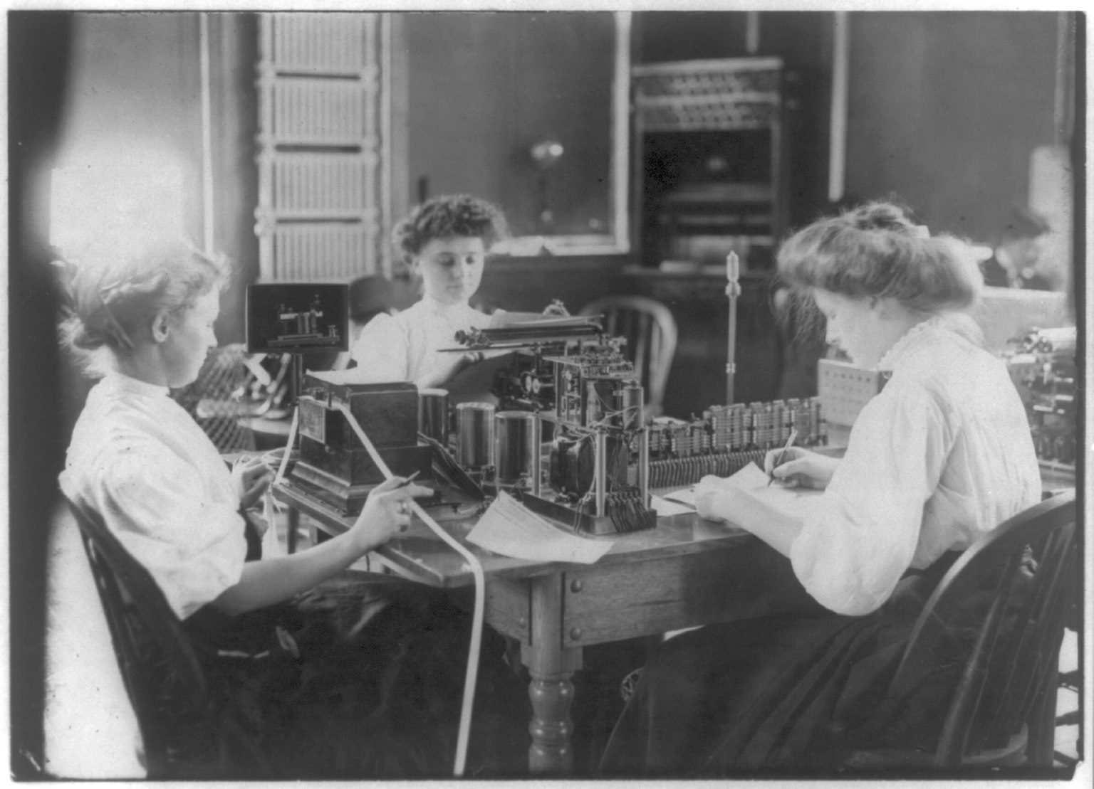 Rows of telegraph operators working side by side at their keys, 1908